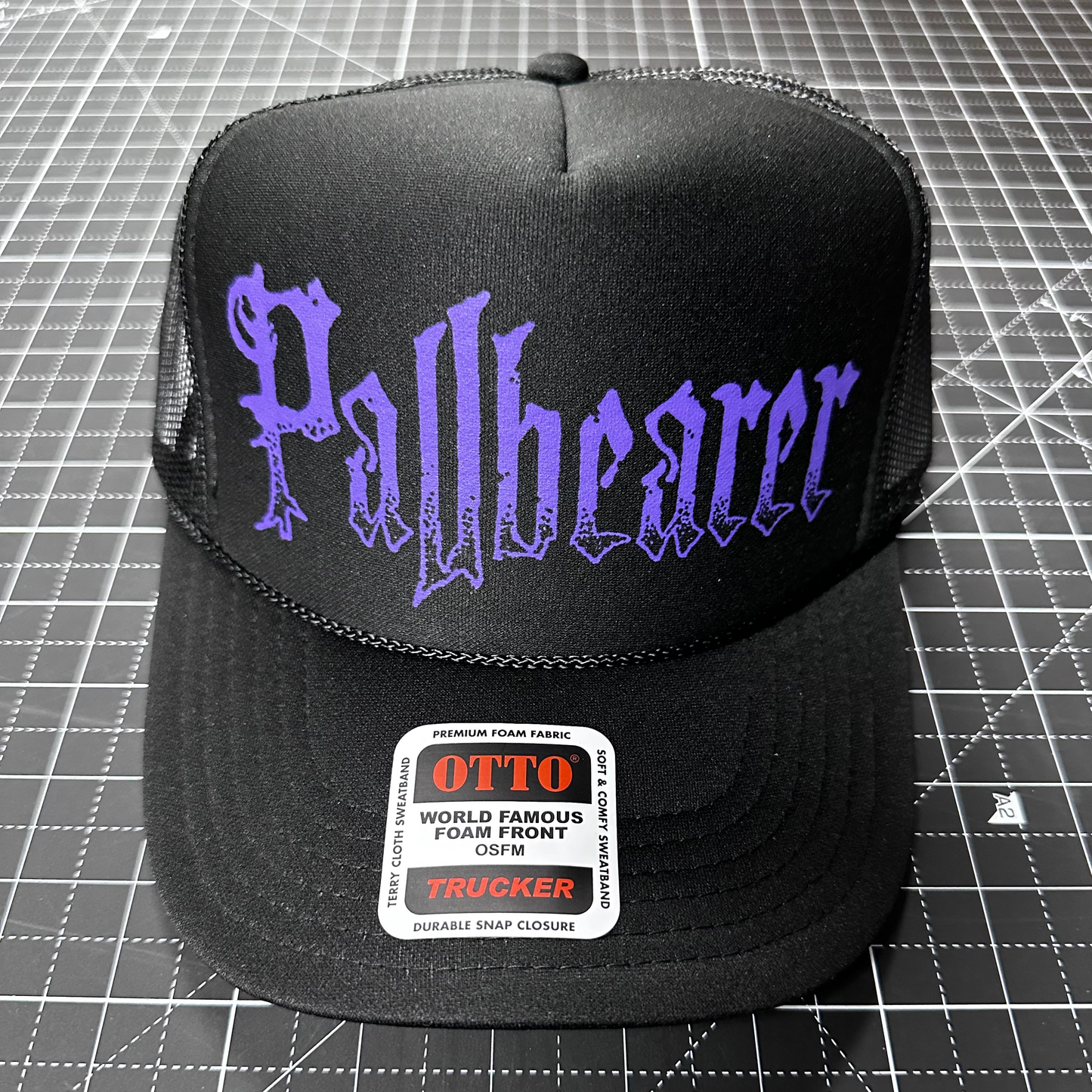 Black cap with 'Pallbearer' text on a grid background