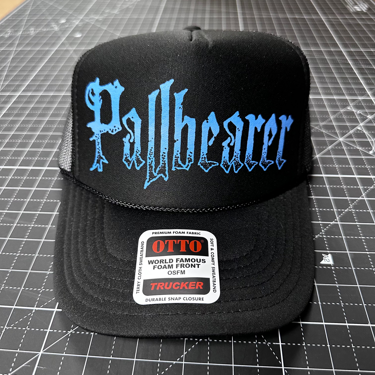 Black cap with 'Pallbearer' logo on a grid surface