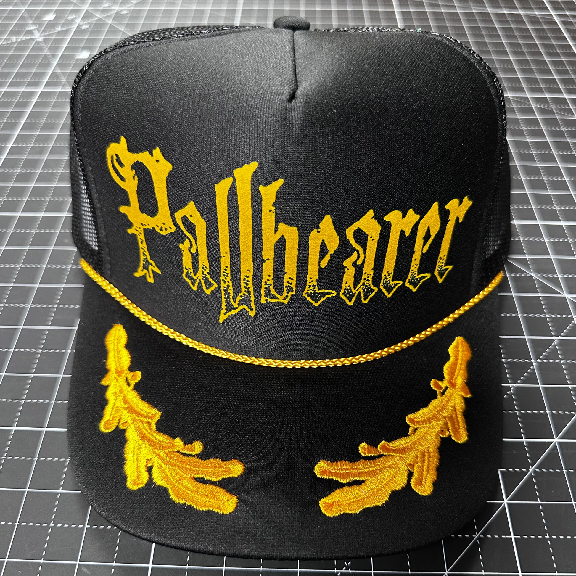 black and gold laurel trucker cap with "Pallbearer" logo