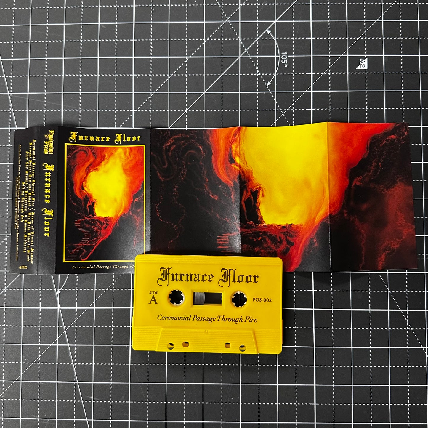 Cassette tape and cover with 'Furnace Floor' design on a grid background