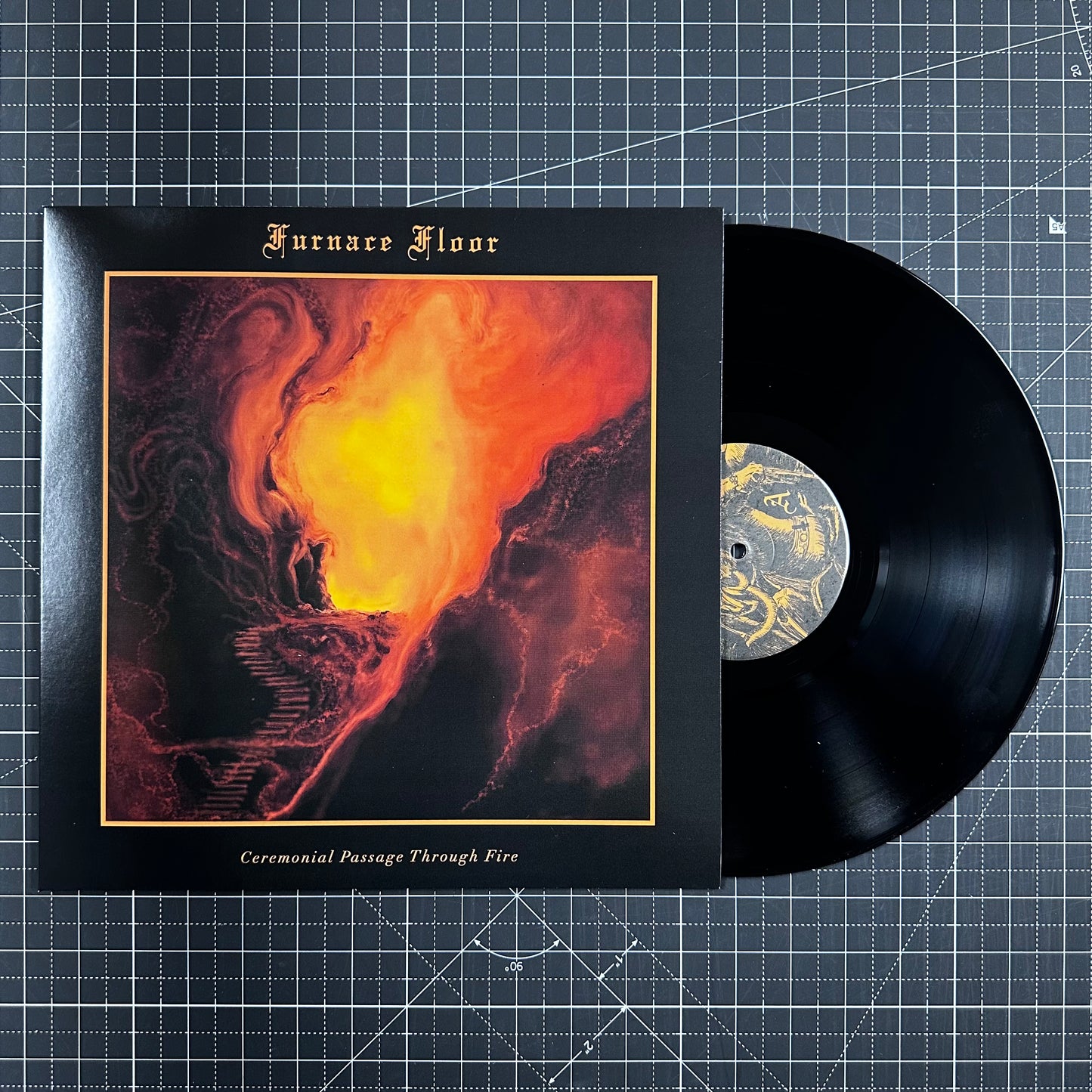 Vinyl record with cover featuring fiery design on a grid background