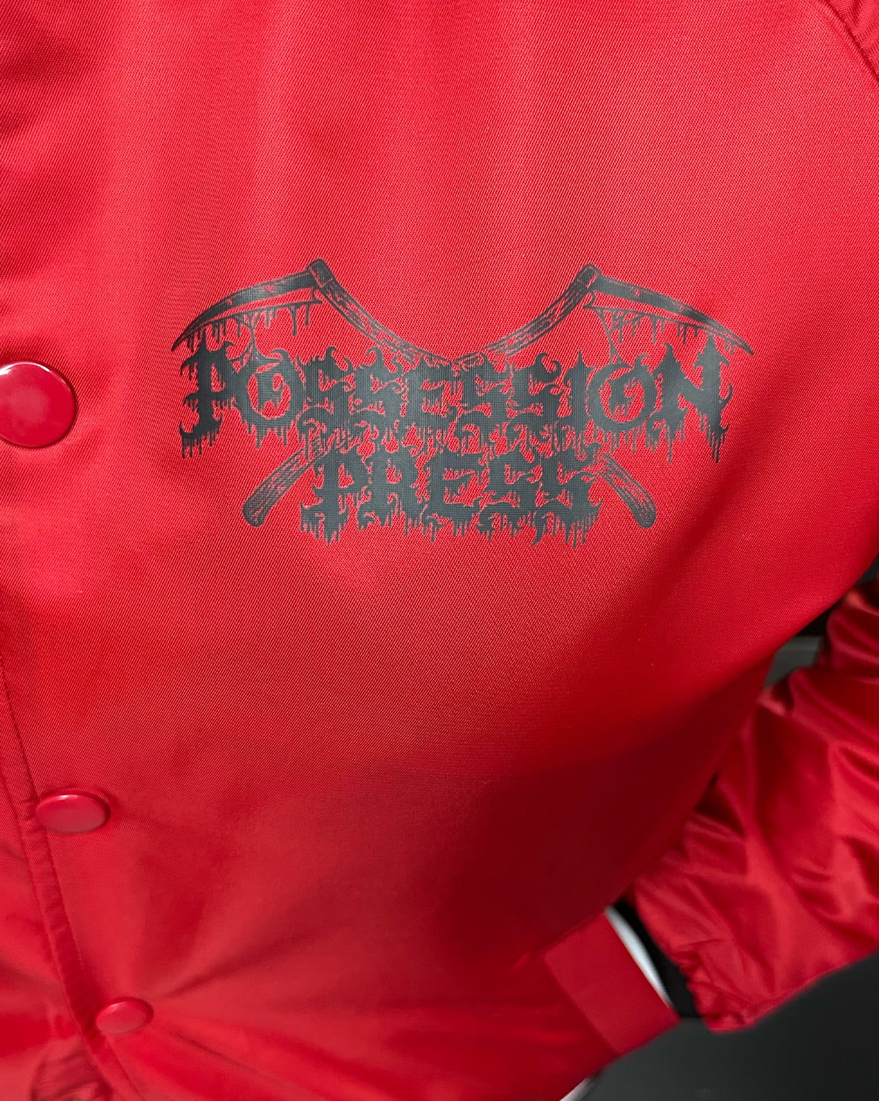 Red jacket with black Possession Press logo and text on a red background
